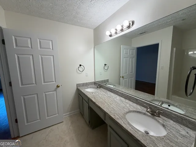 a bathroom with a granite countertop sink and a mirror