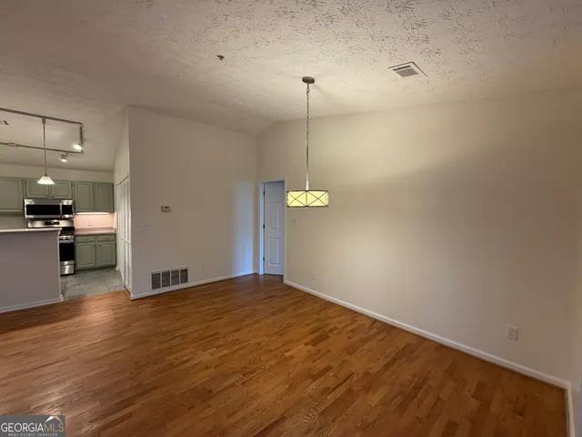a view of empty room with wooden floor