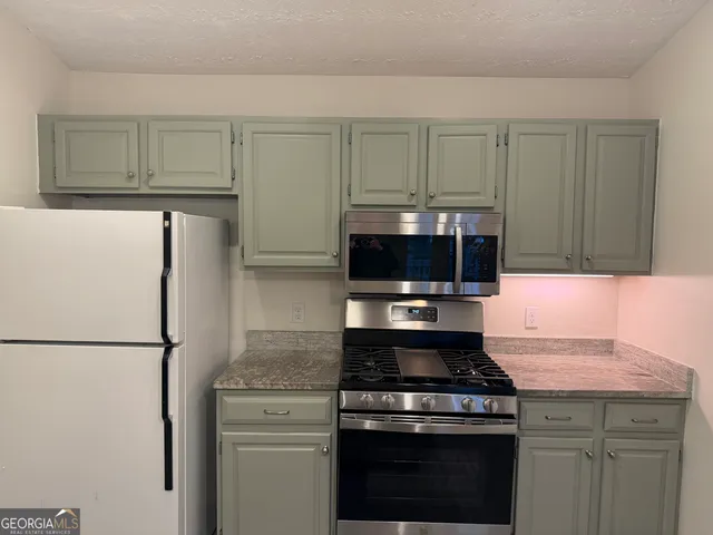 a kitchen with a stove and a refrigerator