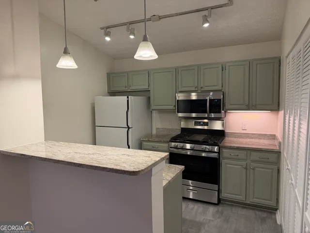 a kitchen with a sink a microwave a stove and refrigerator