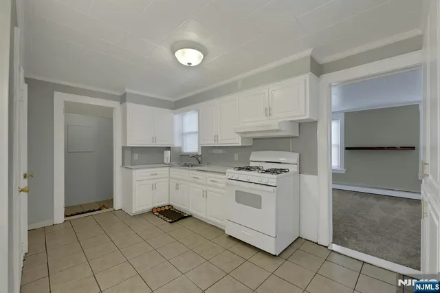 a kitchen with white cabinets and white appliances