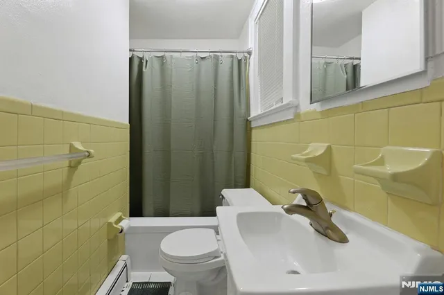 a bathroom with a sink and mirror with toilet
