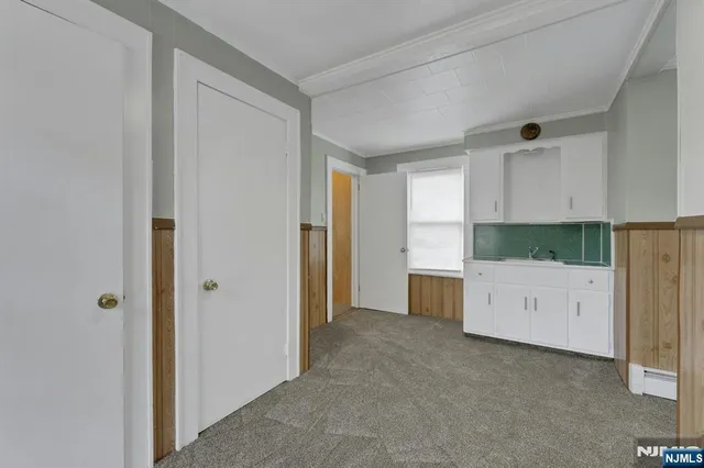 a large white kitchen with a white stove top oven and white cabinet