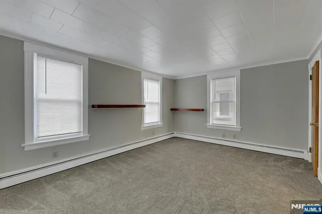 an empty room with windows and closet