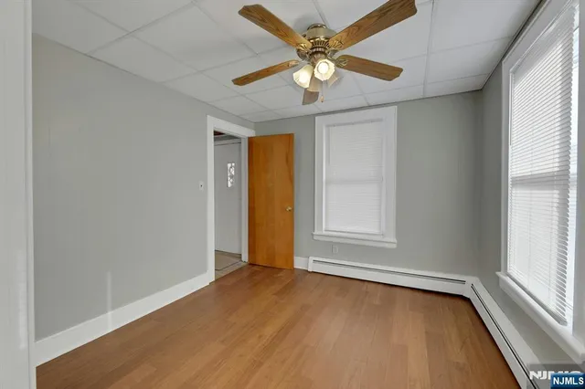 an empty room with a window and a chandelier fan