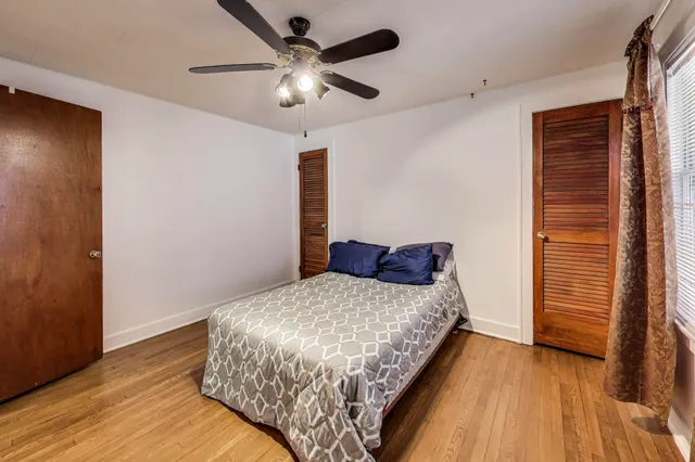 a bedroom with a large bed and a chandelier
