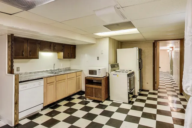 a kitchen with a checkered floor and white cabinets