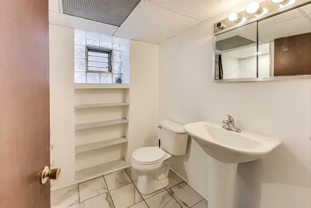 a bathroom with a sink toilet and mirror