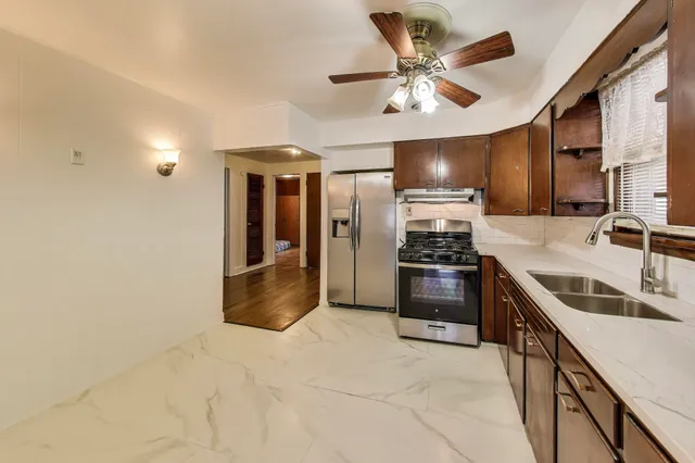 a kitchen with stainless steel appliances a stove a sink and a refrigerator