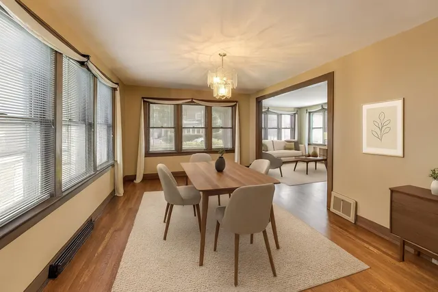 a view of a dining room with furniture a chandelier and wooden floor