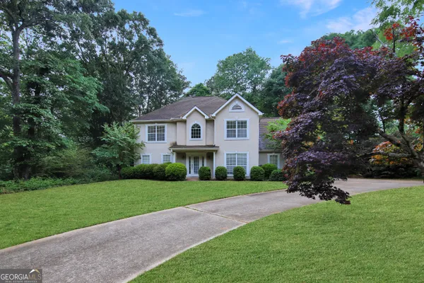 a front view of a house with a garden