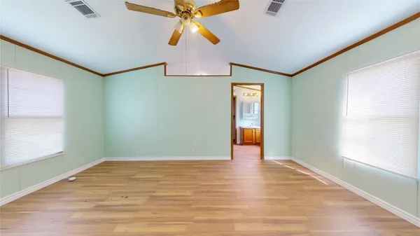 a view of an empty room with window and wooden floor