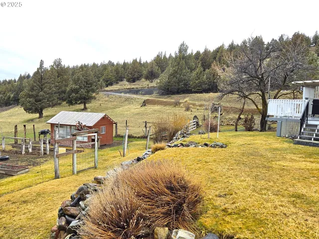 a view of a yard with wooden fence
