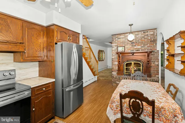 a kitchen with stainless steel appliances granite countertop a refrigerator a stove and a sink with wooden floor