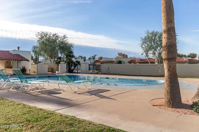 a view of a patio with table and chairs couches and palm trees