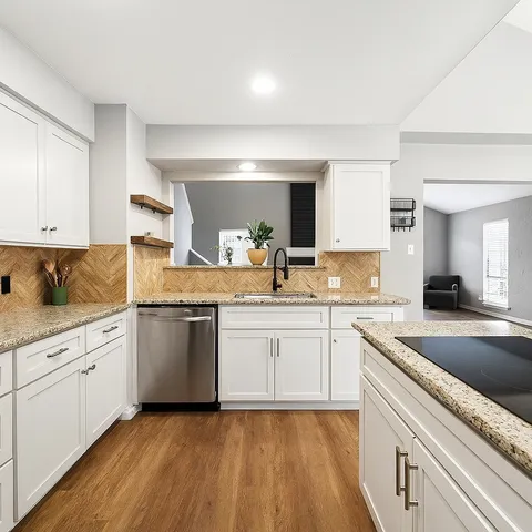 a kitchen with granite countertop white cabinets and white appliances
