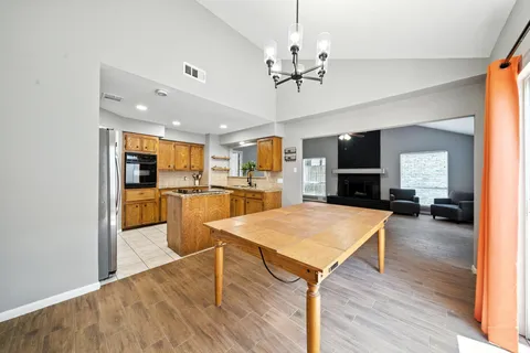 a view of a dining room and livingroom with furniture wooden floor a chandelier