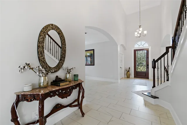 a view of a hallway with entryway wooden floor and a chandelier