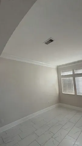 an empty room with a white cabinet and a window