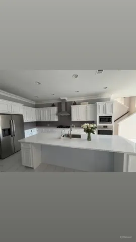 a view of kitchen with kitchen island white cabinets and stainless steel appliances