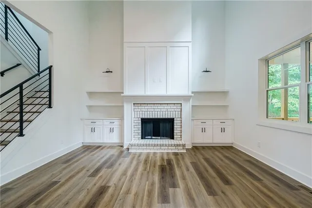 a view of a livingroom with wooden floor and a fireplace