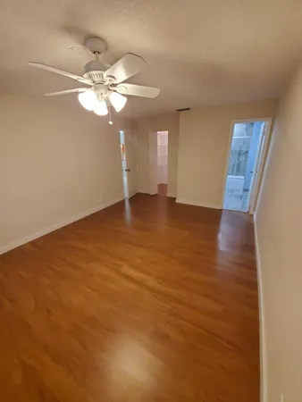 a view of an empty room with window and wooden floor