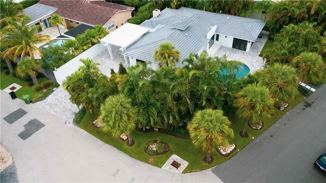a view of a house with a yard and potted plants