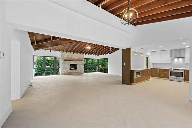 a large kitchen with stainless steel appliances kitchen island a large counter top and wooden floors