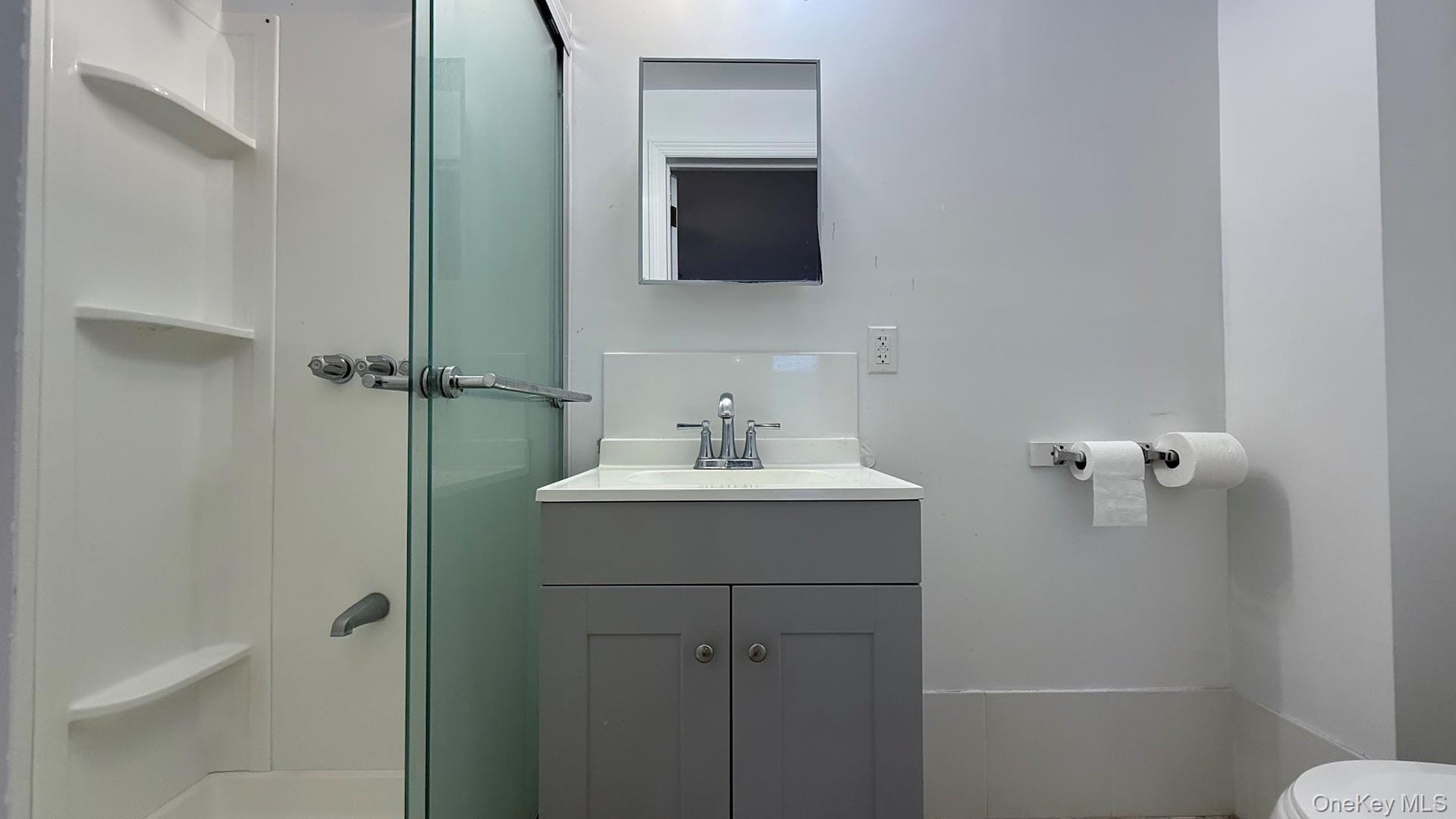 15 Prospect Street, Unit 2 Great Neck, NY 11021 - Photo 4 of 11 a bathroom with a sink and mirror