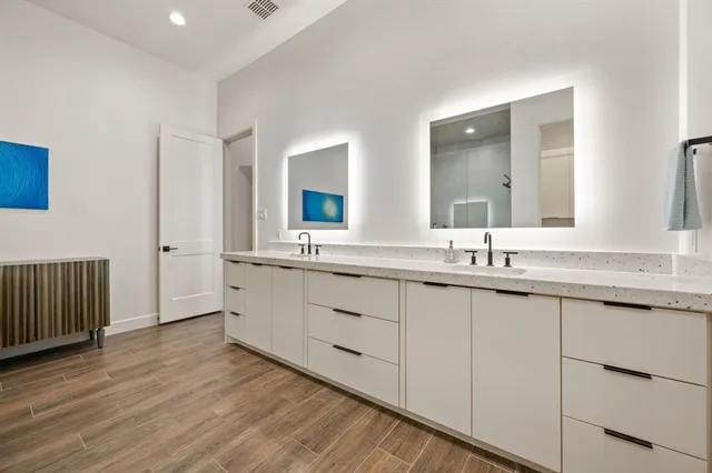 a bathroom with double vanity sink a vanity and mirror
