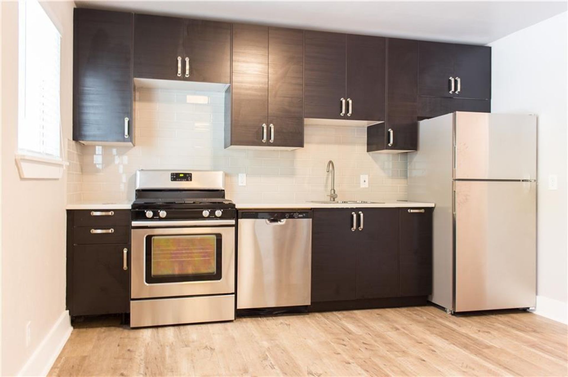 1302 East 52nd Street, Unit 101 Austin, TX 78723 - Photo 1 of 8 a kitchen with stainless steel appliances granite countertop a refrigerator a stove a sink and a refrigerator