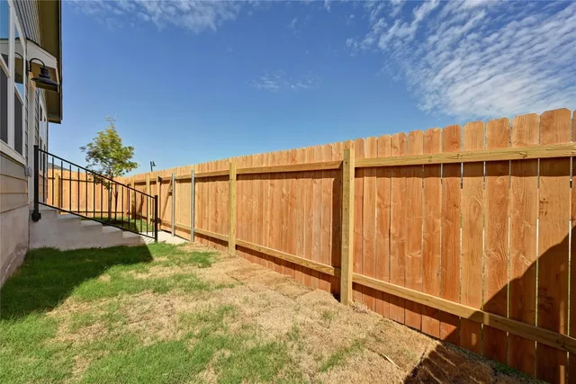 a view of a backyard with wooden fence