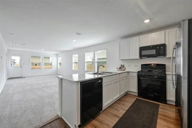 a kitchen with stainless steel appliances granite countertop a stove sink and cabinets