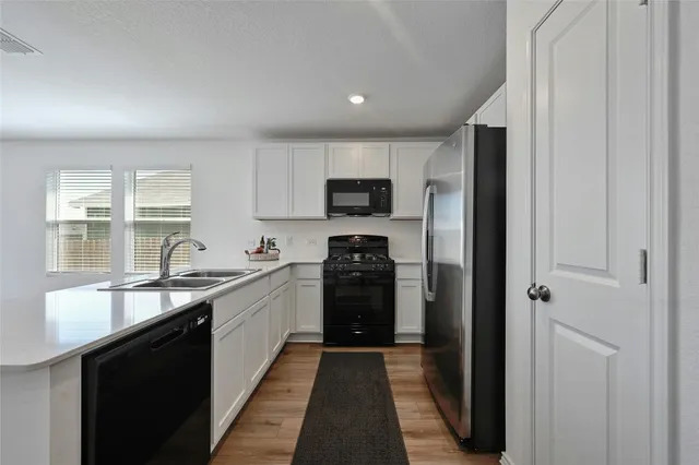 a kitchen with granite countertop white cabinets and stainless steel appliances