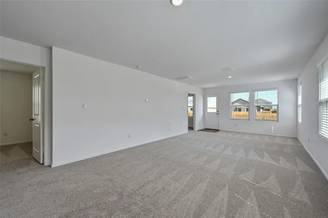 a view of an empty room with window and fire place