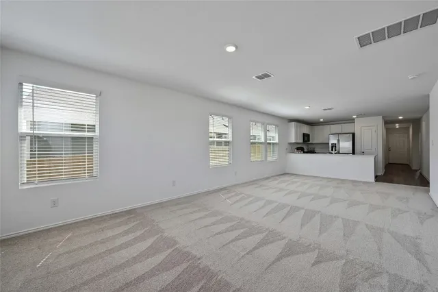 a view of an empty room with a window and fireplace