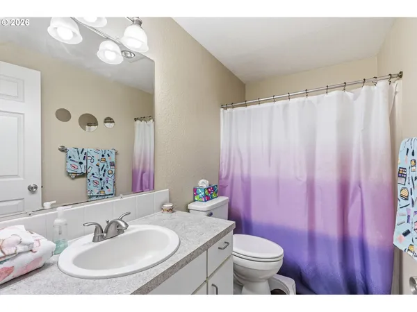 a bathroom with a sink vanity mirror and toilet