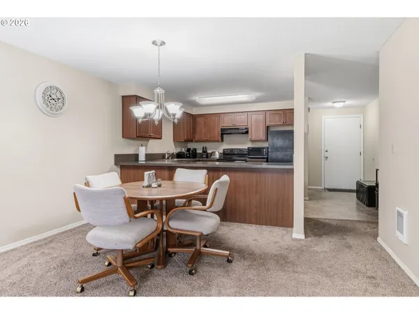 a kitchen with a dining table chairs and a chandelier