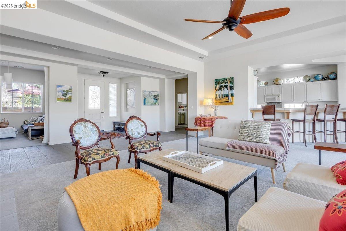 258 Rock Ridge Lane Copperopolis, CA 95228 - Photo 20 of 47 Living room featuring ceiling fan, light tile patterned flooring, a tray ceiling, and light colored carpet
