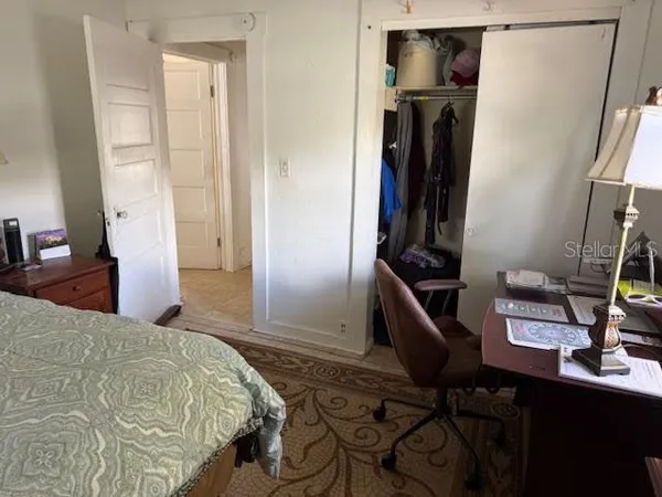 a bedroom with a bed and a flat tv screen next to a window