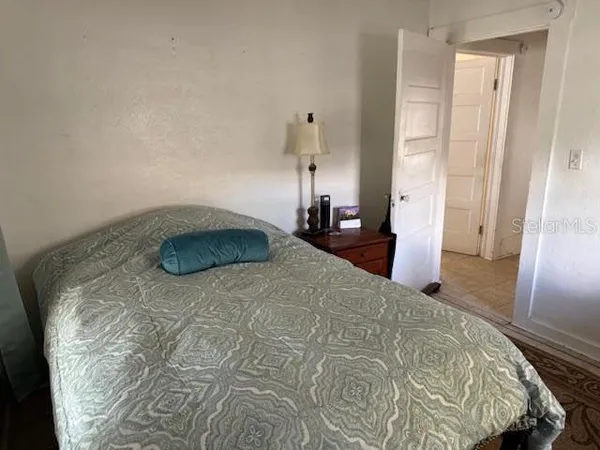 a bedroom with a bed and wooden floor