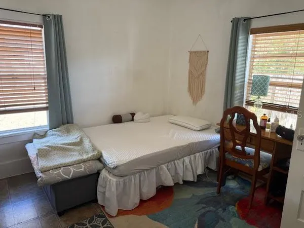 a bedroom with a bed a table and chair