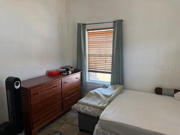 a bedroom with a bed and a window