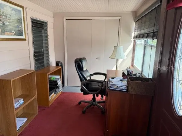 a view of a workspace with furniture and a window