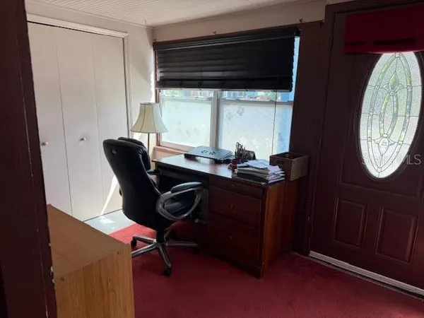 a view of a workspace with furniture and a window