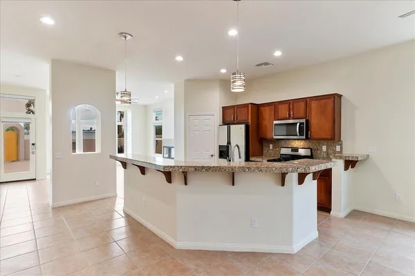 a view of kitchen with stainless steel appliances a sink and a stove