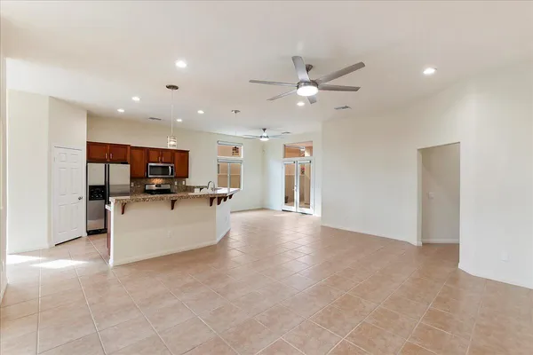 a view of a kitchen with kitchen island stainless steel appliances refrigerator sink and stove