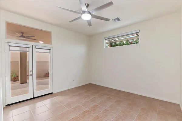 an empty room with windows and fan