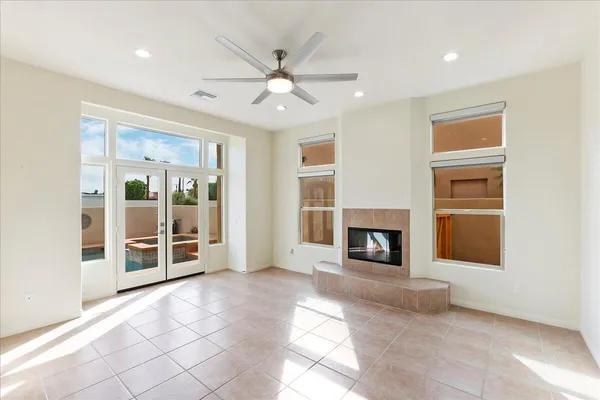 a view of a livingroom with a fireplace chandelier and windows
