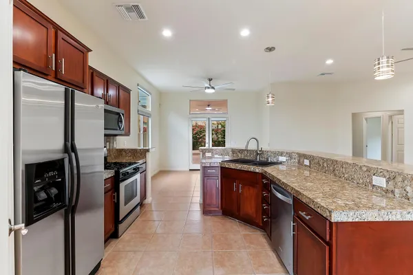 a kitchen with stainless steel appliances granite countertop a sink stove and refrigerator
